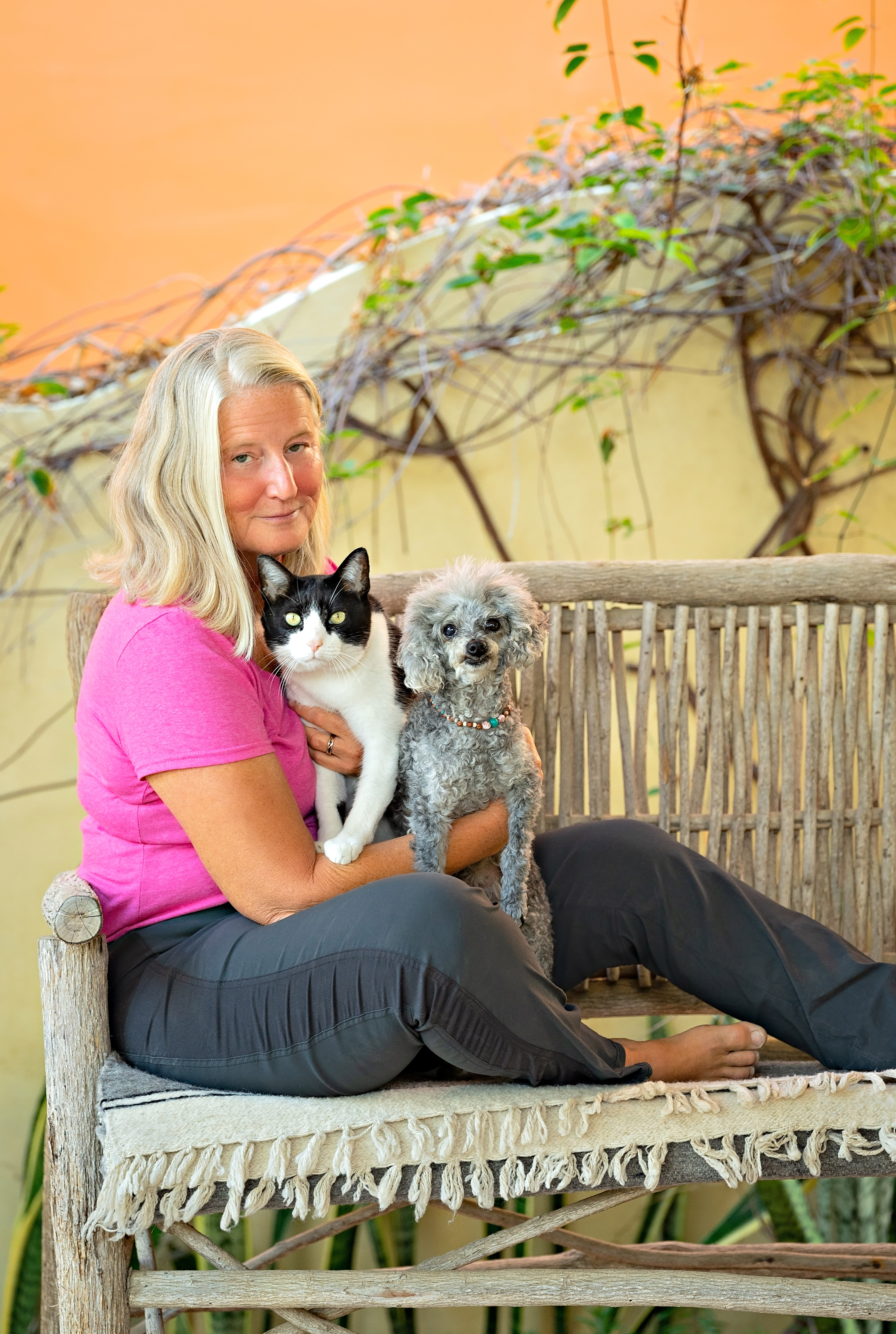 Dr. Ruth Roberts with her cat and poodle on a garden bench